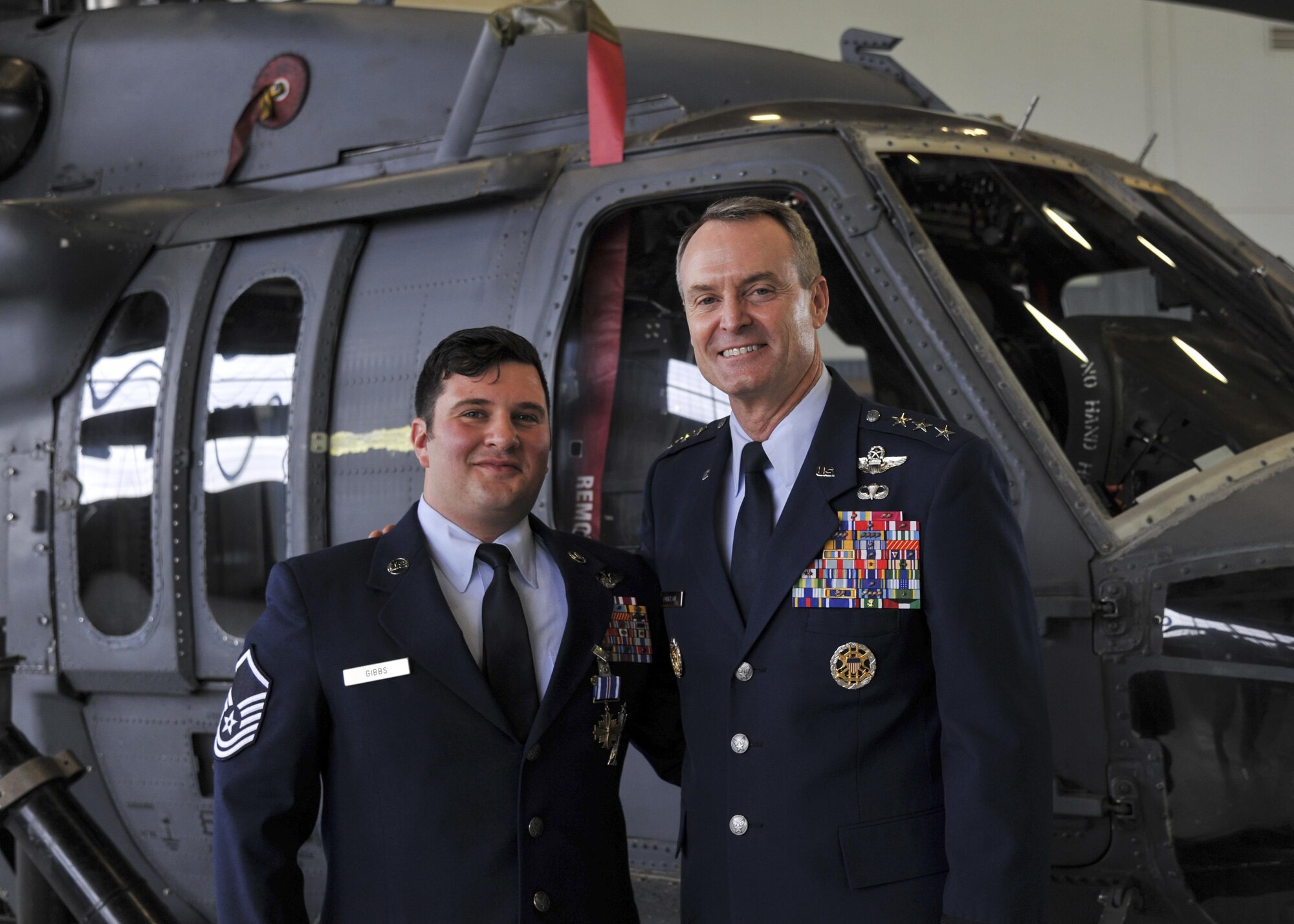Master Sgt. Gregory Gibbs, 512th Rescue Squadron operations superintendent, right, and Lt. Gen. Darryl Roberson, Air Education and Training Command commander, from Joint Base San Antonio, Texas, stand in front of an HH-60 Pave Hawk following the Distinguished Flying Cross medal ceremony at Kirtland Air Force Base, New Mexico, Jan. 13. Ranked as the highest military aviation award, Gibbs received the medal for distinguishing himself as a HH-60 Pave Hawk aerial gunner in a high-risk rescue mission in Afghanistan on May 26, 2011.  