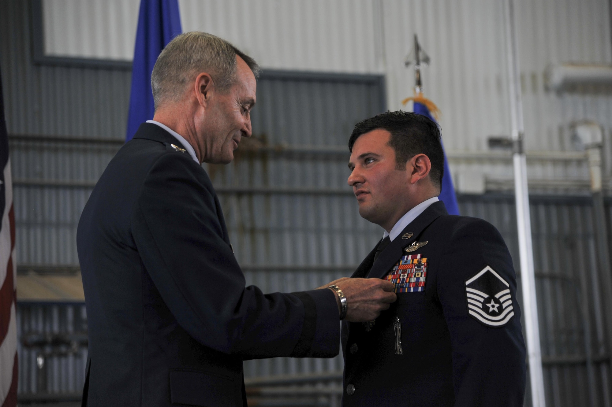 Lt. Gen. Darryl Roberson, (left) Air Education and Training Command commander, Joint Base San Antonio, Texas, presents Master Sgt. Gregory Gibbs, 512th Rescue Squadron operations superintendent, with the Distinguished Flying Cross medal at Kirtland Air Force Base, New Mexico, Jan. 13. Ranked as the highest military aviation award, Gibbs received the medal for distinguishing himself as a HH-60 Pave Hawk, aerial gunner in a high risk rescue mission in Afghanistan on May 26, 2011. Gibbs' split-second decision-making skills saved the lives of nine military members.  