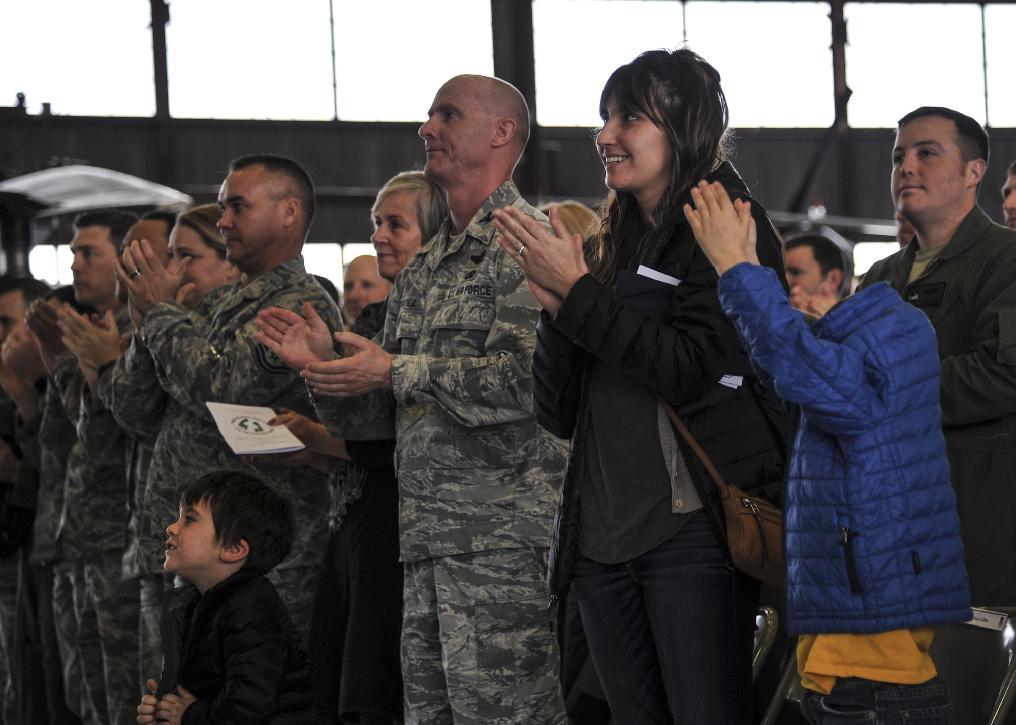 Family and friends applaud during the Distinguished Flying Cross medal ceremony at Kirtland Air Force Base, New Mexico, Jan. 13. The medal was awarded to MSgt. Gregory Gibbs, 512th Rescue Squadron operations superintendent, whose split decision making skills during a 2011 rescue mission in Afghanistan saved not only the three soldiers trapped, but the crew flying Pedro 55. (U.S. Air Force photo by Senior Airman Nigel Sandridge)