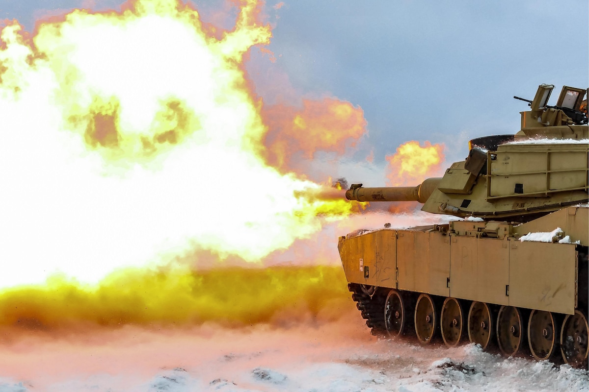 Soldiers fire a live round from a battle tank.
