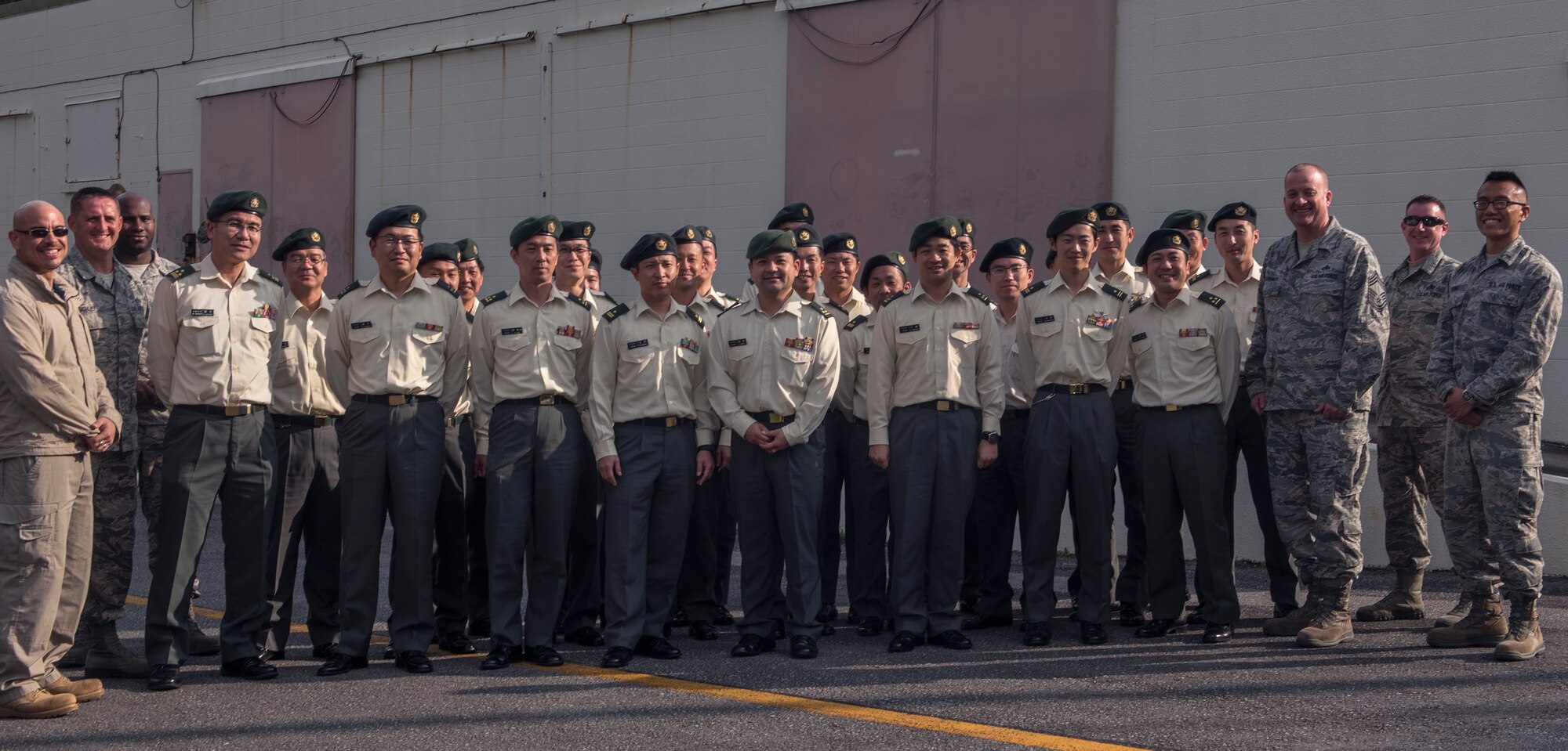 U.S. Air Force and Japan Ground Self-Defense Force members stand united for a group photo after a tour of the 18th Munitions Squadron Jan. 11, 2017, at Kadena Air Base, Japan. The U.S.-Japan security alliance remains the cornerstone of peace and security in the Pacific region, and it has been this way for more than 50 years. (U.S. Air Force photo by Airman 1st Class Corey Pettis/Released)