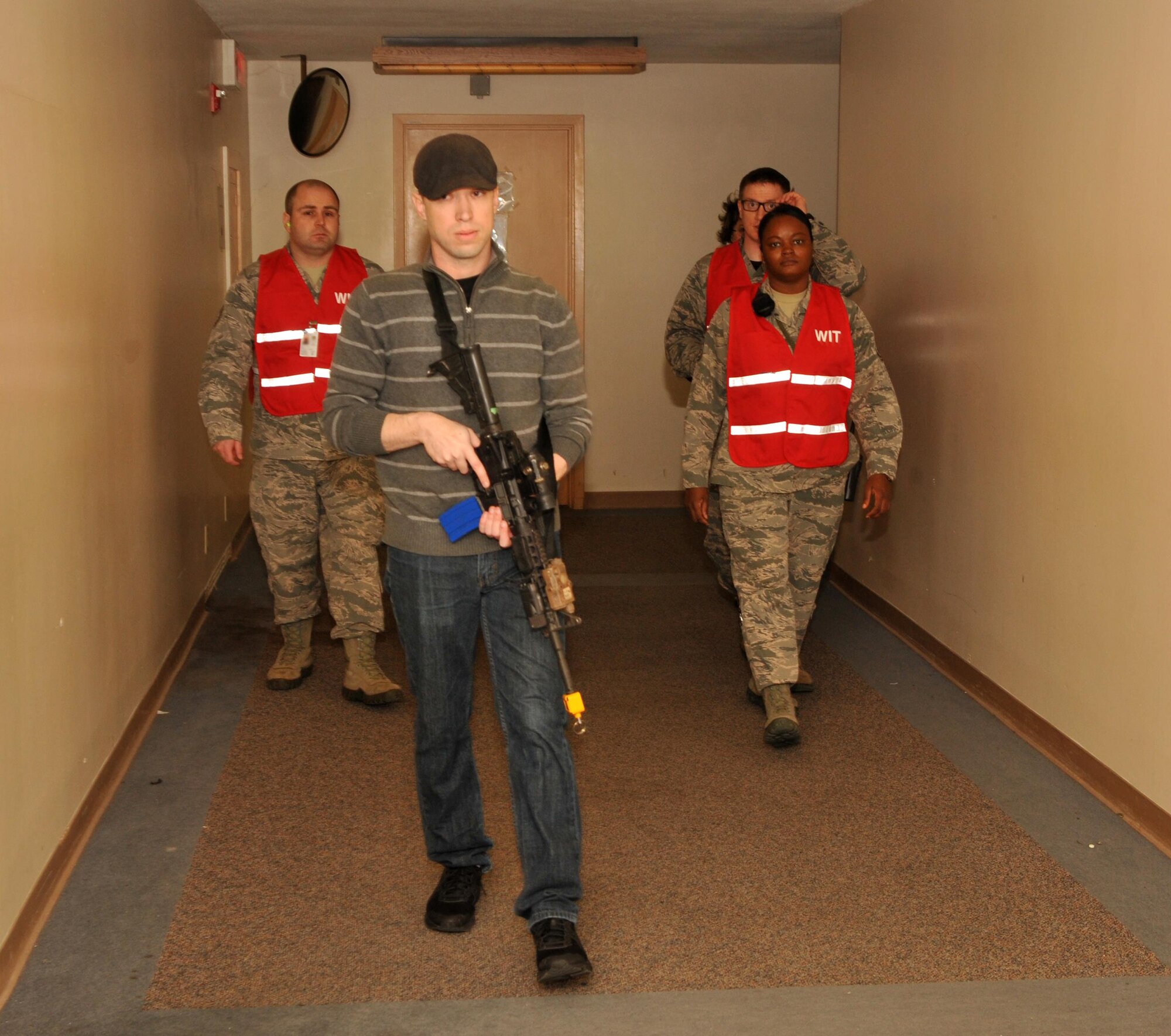 Staff Sgt. Chris Hall, 9th Security Forces member, plays the role of an active shooter and is followed by members of the Wing Inspection Team during an exercise Jan. 13, 2017 at Beale Air Force Base, California. The exercise took place without a majority of the base populous being informed ahead of time in order to better test the readiness of Team Beale. (U.S. Air Force photo/Airman Tristan D. Viglianco)