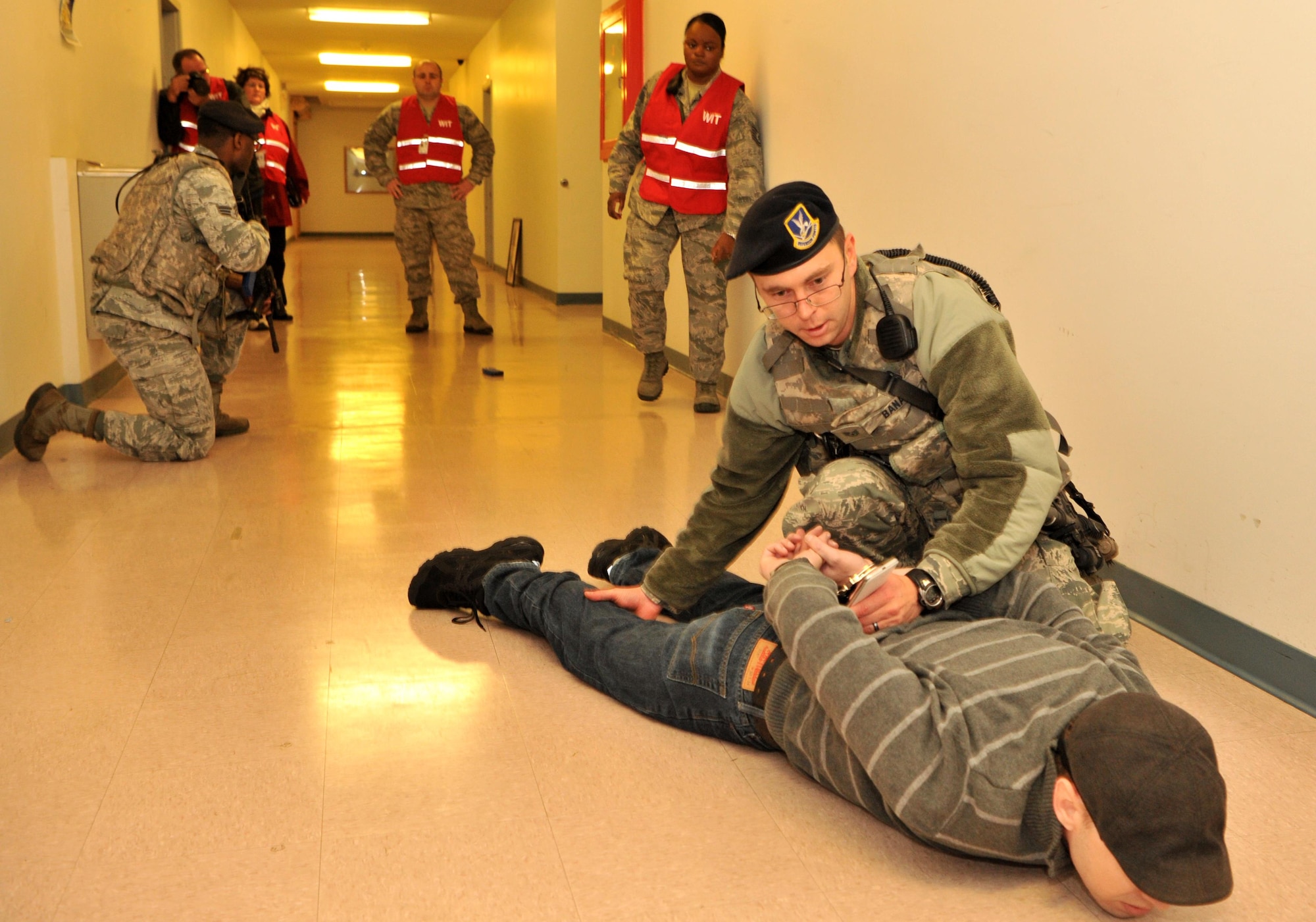 9th Security Forces Squadron Airmen apprehend an active shooter during an exercise as the Wing Inspection Team looks on Jan. 13, 2017 at Beale Air Force Base, California.  The exercise tested the response of individuals and units on base. (U.S. Air Force photo/Airman Tristan D. Viglianco)