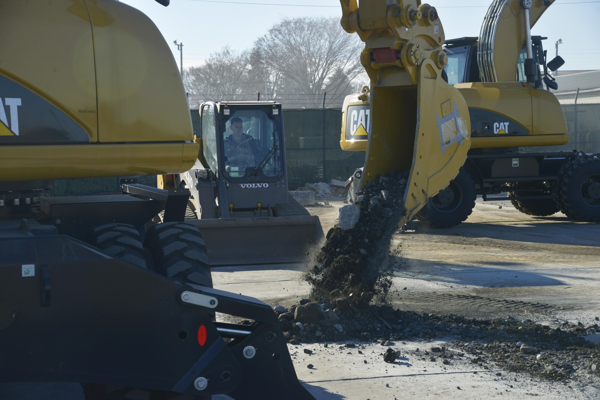 A member of the 374th Civil Engineer Squadron pours dirt on the ground during a simulated crater repair scenario at Yokota Air Base, Japan, Jan. 12, 2017. In real world scenarios, Airmen will fill the crater with dirt to make it level with the ground to keep the flying mission running. (U.S. Air Force photo by Staff Sgt. David Owsianka)