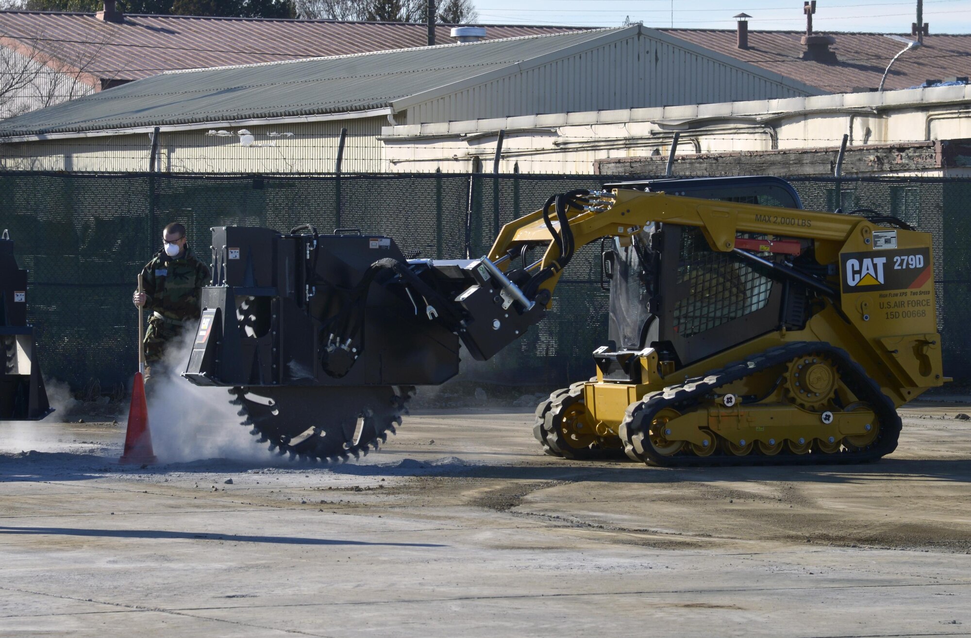 Members of the 374th Civil Engineer Squadron cut part of the cement during a simulated crater repair scenario at Yokota Air Base, Japan, Jan. 12, 2017. In a real world scenario, the Airmen will ensure the ground is level prior to placing a mat over the crater to ensure aircraft can land and takeoff from the flight line. (U.S. Air Force photo by Staff Sgt. David Owsianka)