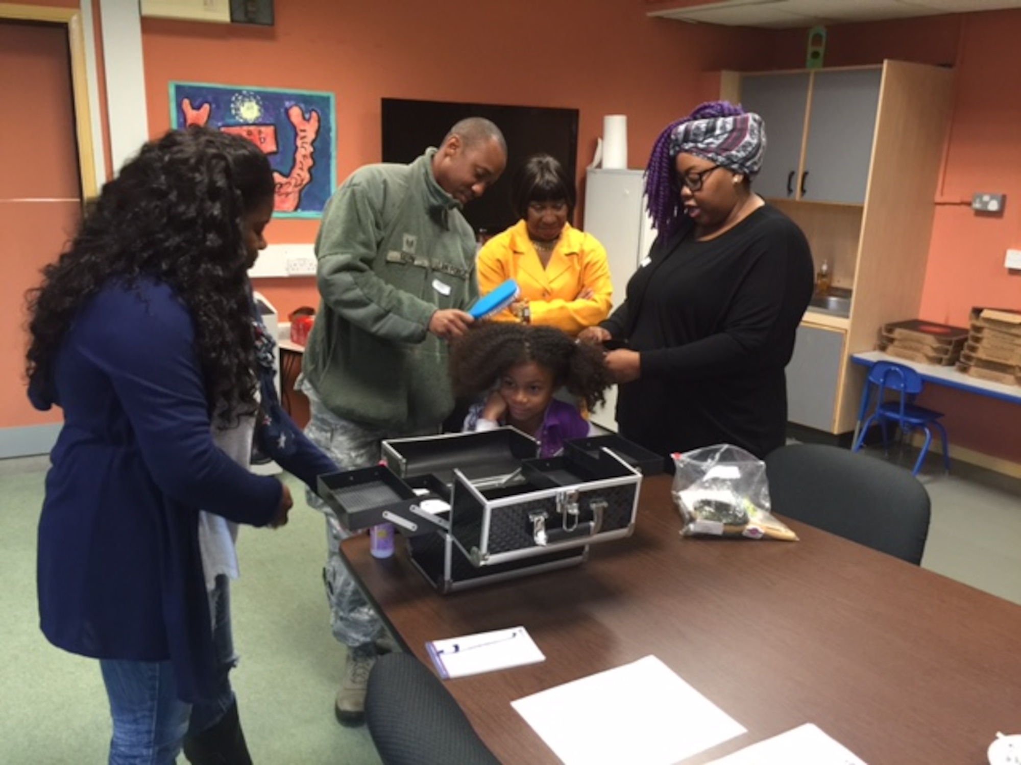 A father practices styling hair at a Single Dad Association meeting at Royal Air Force Lakenheath, England. The SDA is a group of single fathers from the tri-base area who hold monthly meetings to network, learn from each other and discuss how to talk to their kids about touchy subjects. (Courtesy Photo)