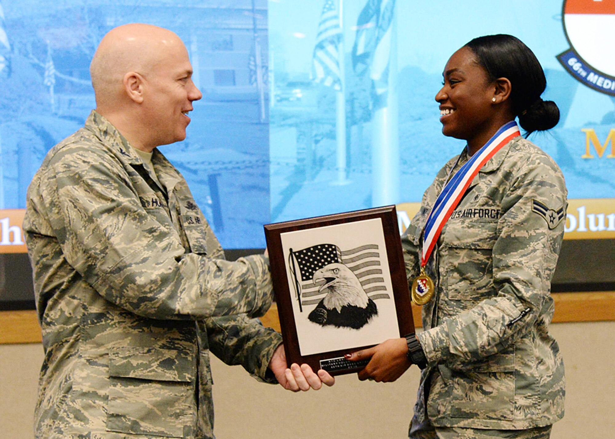 Col. Roman L. Hund, 66th Air Base Group commander, presents Airman First Class Lakiesha J. Grant the Military Volunteer of the Year award during the group's annual awards ceremony at the Hanscom Conference Center Jan. 17. During the ceremony, the air base group recognized their top performers for 2016. (U.S. Air Force photo by Linda LaBonte Britt)