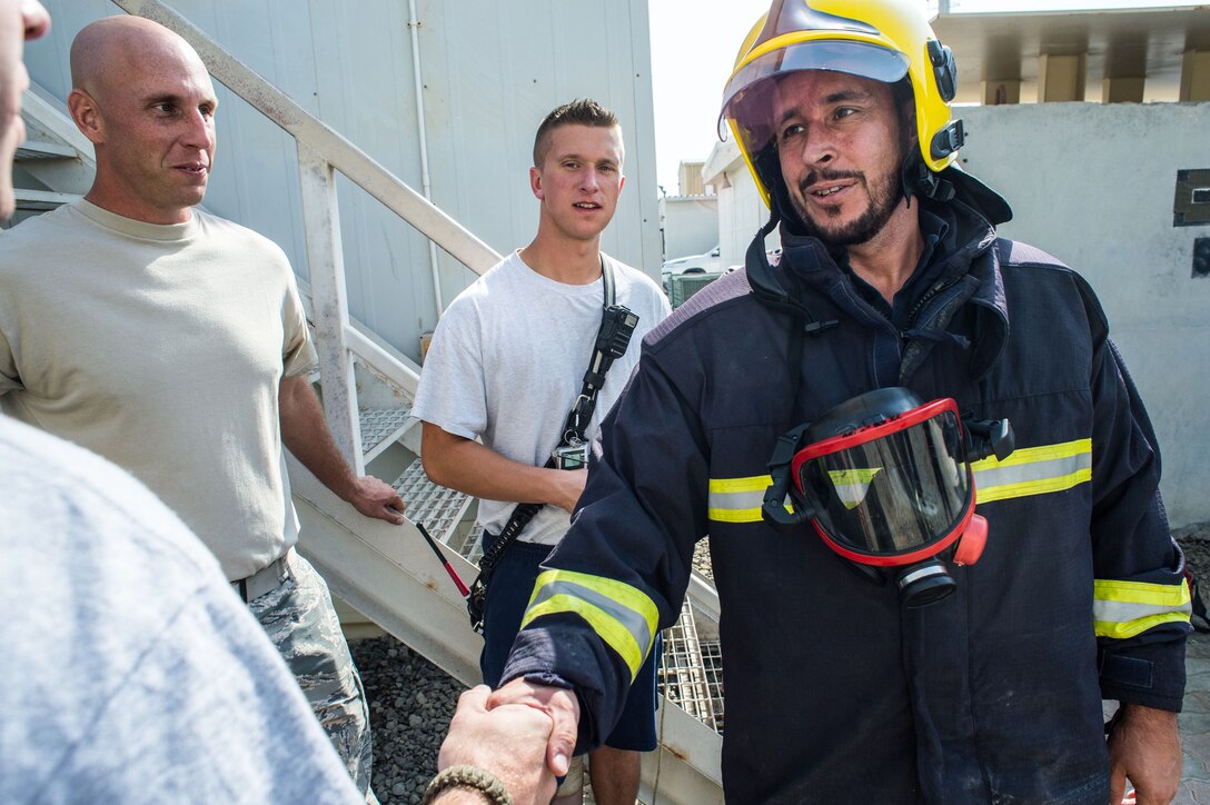 A French Air Force firefighter celebrates with U.S. Air Force firefighters after completing a firefighting confidence course at an undisclosed location in Southwest Asia, Jan. 17, 2017. 6 members of the FAF participated in the event. During the course, U.S. and French personnel supported each participant as they progressed through the obstacles. (U.S. Air Force photo/Senior Airman Tyler Woodward)