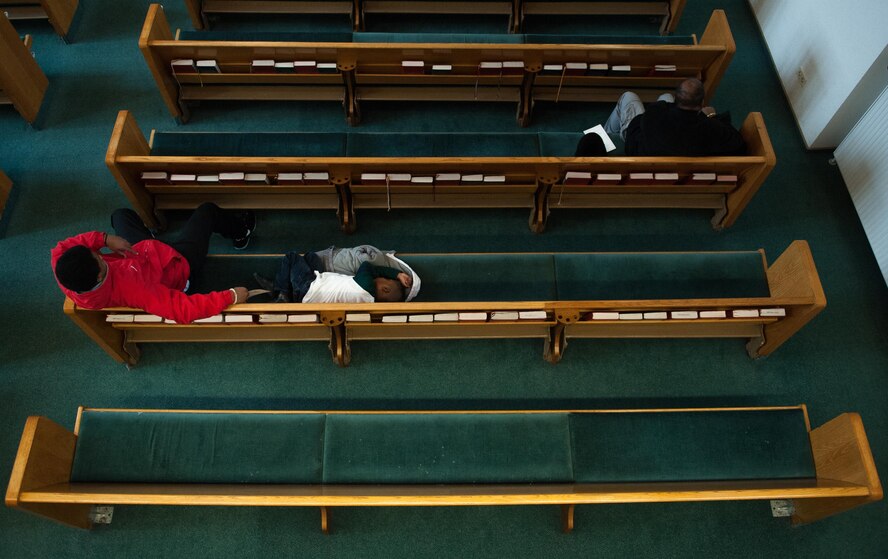 A young man and his brother lay back in a pew as they wait for a Martin Luther King Jr. commemoration at Ramstien Air Base, Germany, Jan. 13, 2017. Martin Luther King Jr. Day is an American federal holiday marking the birthday of Dr. King. It is observed on the third Monday of January each year, which is around his birthday, Jan. 15. (U.S. Air Force photo by Airman 1st Class Lane T. Plummer)
