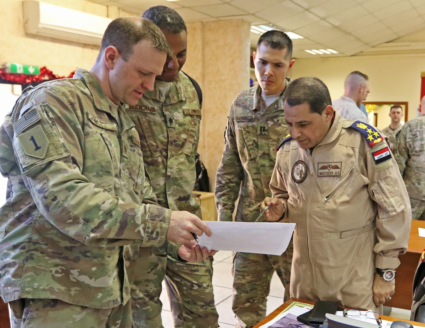 U.S. Air Force Maj. Aaron Tillman, CJOC-B Air Advisor, discusses logistics with Iraqi Brig. Gen. Mustafa, Iraq Air Director, in the Combined Joint Operations Center -- Baghdad, Jan. 7. The multi-national Coalition provides assistance to the Iraqi Security Forces in the ongoing effort to defeat the Islamic State of the Levant.