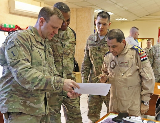 U.S. Air Force Maj. Aaron Tillman, CJOC-B Air Advisor, discusses logistics with Iraqi Brig. Gen. Mustafa, Iraq Air Director, in the Combined Joint Operations Center -- Baghdad, Jan. 7. The multi-national Coalition provides assistance to the Iraqi Security Forces in the ongoing effort to defeat the Islamic State of the Levant.