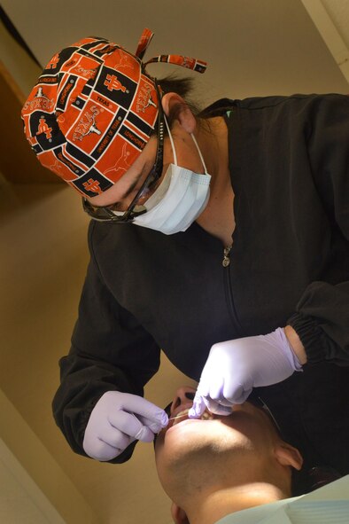 Staff Sgt. Stephanie Garica, 5th Medical Operations Squadron NCO in charge of preventive dentistry, flosses a patient's teeth at Minot Air Force Base, N.D., Jan. 10, 2017. The 5th Medical Group dental clinic is preparing for Children's Dental Health Month, which promotes healthy habits to children. (U.S. Air Force photo/Airman 1st Class Jessica Weissman)