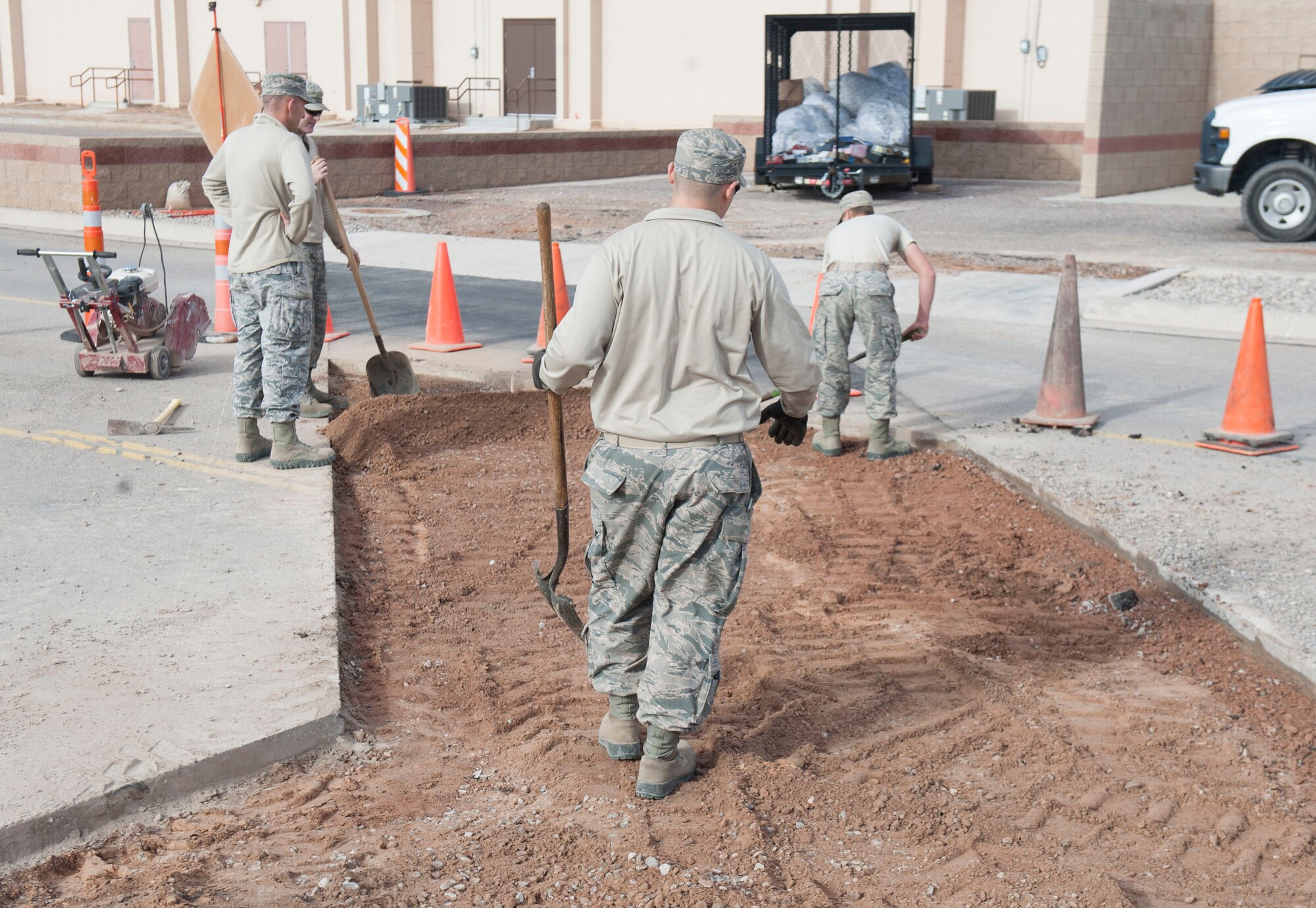 Pavement and Equipment craftsmen, assigned to the 49th Civil Engineer Squadron, level off soil in preparation to place fresh asphalt onto the roadway at Holloman Air Force Base, N.M., January 17, 2017. A utility break occurred under the roadway causing for the 49th CES to quickly respond and fix the problem. (U.S. Air Force photo by Airman Ilyana A. Escalona)