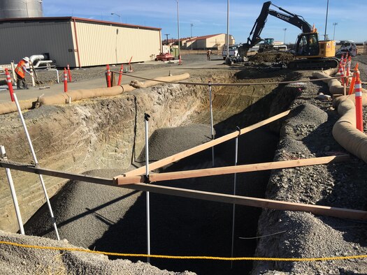 Heavy equipment operators fill in the first subgrade sulfate reactor at Travis Air Force Base, Calif., in the summer of 2016 with a mixture of gravel and crushed drywall, creating the right conditions for naturally occurring microbes to use fuel contaminants as food. The reactor is powered by a solar panel array, making this cleanup technology nonintrusive and environmentally friendly. (Courtesy photo by Jordan Ollanik)  