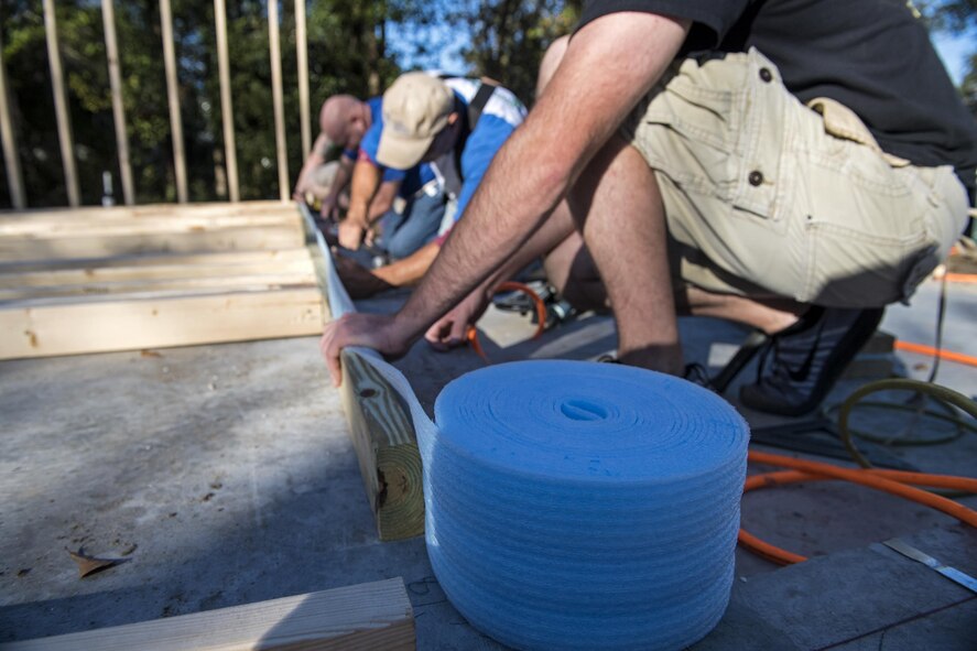 Volunteers secure Styrofoam to the bottom of a frame for Habitat for Humanity, Jan. 14, 2017, in Valdosta, Ga. The foam acts as a buffer between the concrete slab and the wood of the frame. (U.S. Air Force photo by Airman 1st Class Janiqua P. Robinson)