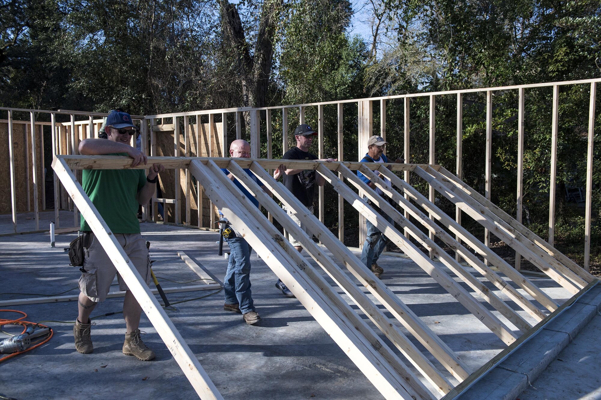 Volunteers lift a frame before nailing it into place for Habitat for Humanity, Jan. 14, 2017, in Valdosta, Ga. These volunteers measured and constructed the frame before putting it in place as the front wall for the home. (U.S. Air Force photo by Airman 1st Class Janiqua P. Robinson)