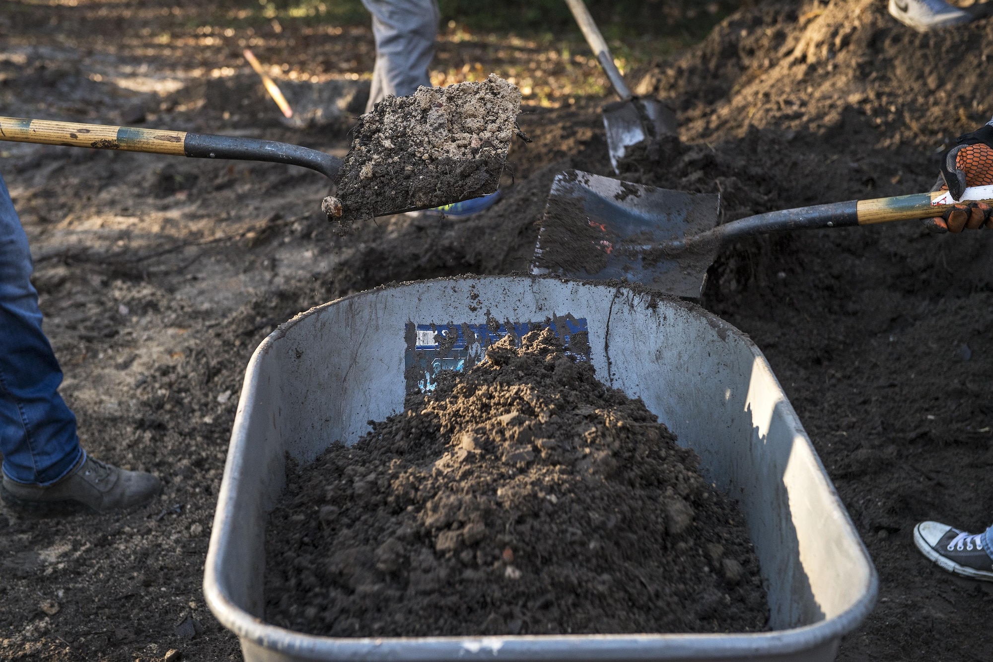 Volunteers shovel dirt into a wheelbarrow in support of Habitat for Humanity, Jan. 14, 2017, in Valdosta, Ga. Volunteers from Moody Air Force Base and the local community came together to build a home for a family in need. (U.S. Air Force photo by Airman 1st Class Janiqua P. Robinson)