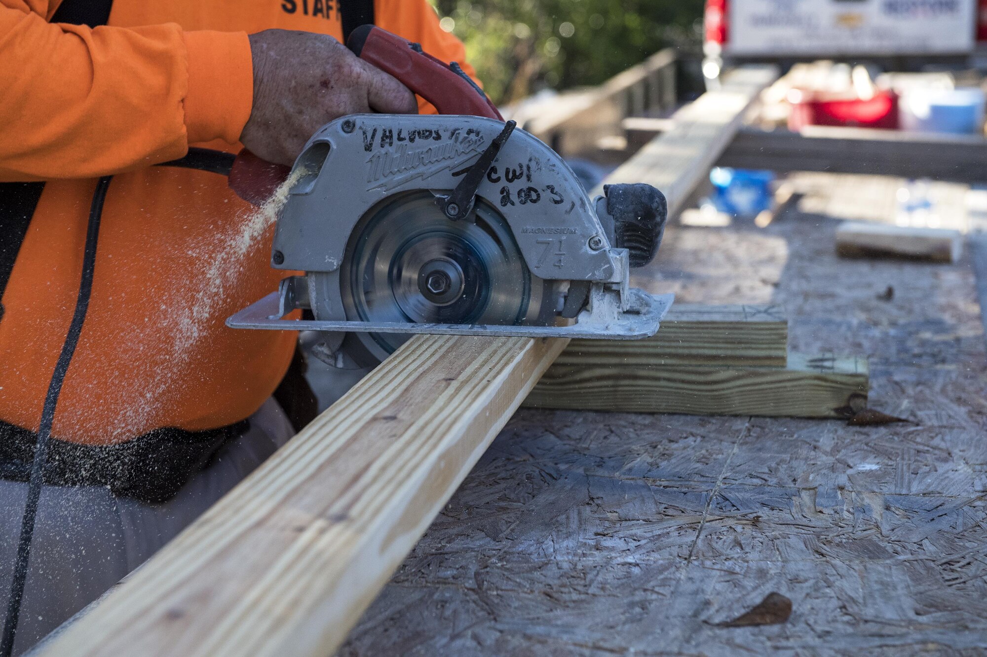 A volunteer uses a circular saw to cut through a piece of wood Jan. 14, 2017, in Valdosta, Ga. This piece of wood was used to secure the frame of the house by nailing it to the top of the frame and will attach to the structural beams that will support the roof. (U.S. Air Force photo by Airman 1st Class Janiqua P. Robinson)