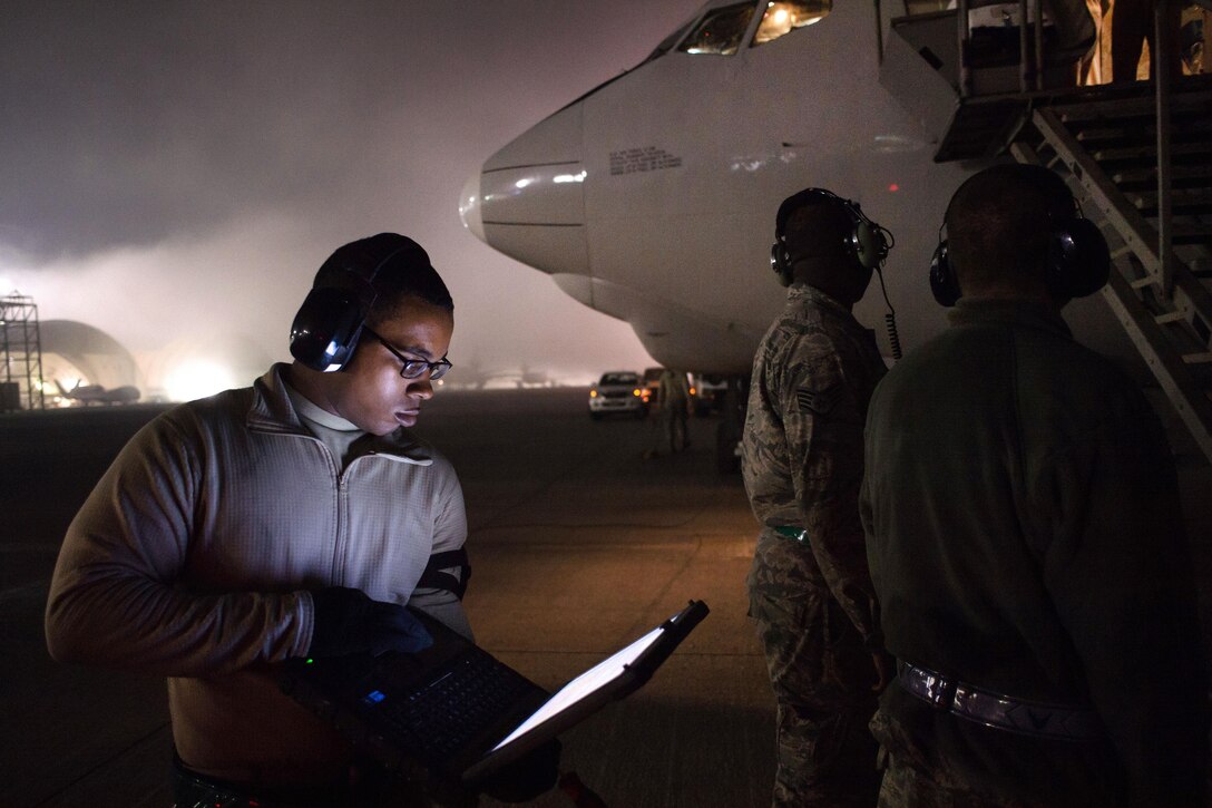 An airman reviews a maintenance checklist on his laptop before a post-flight inspection on an E-3 Sentry supporting Combined Joint Task Force Operation Inherent Resolve in Southwest Asia, Jan. 12, 2017. Air Force photo by Senior Airman Tyler Woodward