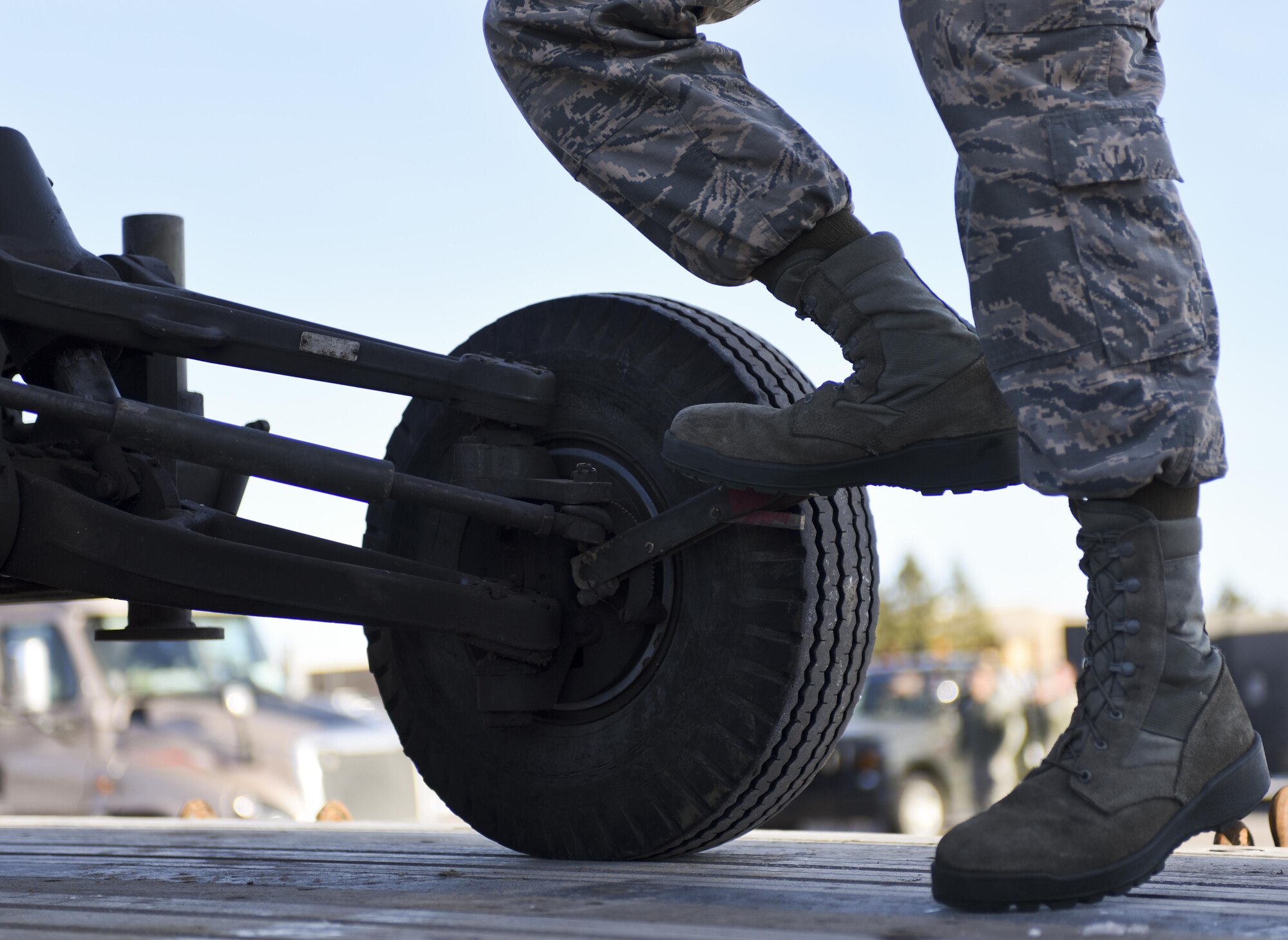 An Airman assigned to the 28th Logistics Readiness Squadron, applies a foot brake to a piece of equipment after loading it onto a truck Jan. 17, 2017, at Ellsworth Air Force Base, S.D. Airmen from the 28th LRS and the 28th LRS Travel Management Office loaded approximately 321k pounds of equipment onto 17 trucks in two days. (U.S. Air Force photo by Airman 1st Class Randahl J. Jenson)