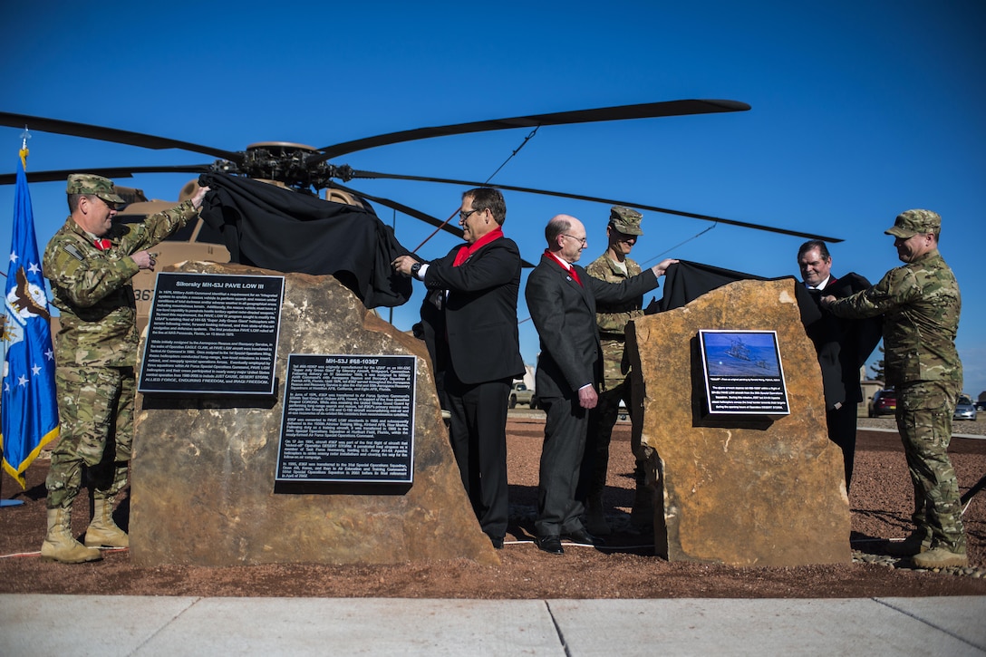 Attendees of a MH-53J Pave Low III dedication ceremony unveil plaques at the end of the ceremony Jan 17, 2017, at the air park on Cannon Air Force Base, N.M. The plaques describe the aircraft’s history and mission accomplishments. (U.S. Air Force photo by Senior Airman Luke Kitterman/Released) 
