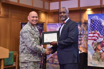 U.S. Air Force Col. Jimmy Canlas, 437 Airlift Wing commander, presents Melvin D. Willis, Space and Naval Warfare Systems Center – Atlantic Enterprise Information Systems Business manager, with a certificate of appreciation during the Dr. Martin Luther King Jr. remembrance event at the chapel Jan. 17, 2017 at Joint Base Charleston, South Carolina. Willis was the guest speaker for the ceremony honoring King’s legacy. Willis is a former command chief master sergeant from the 437 Airlift Wing.