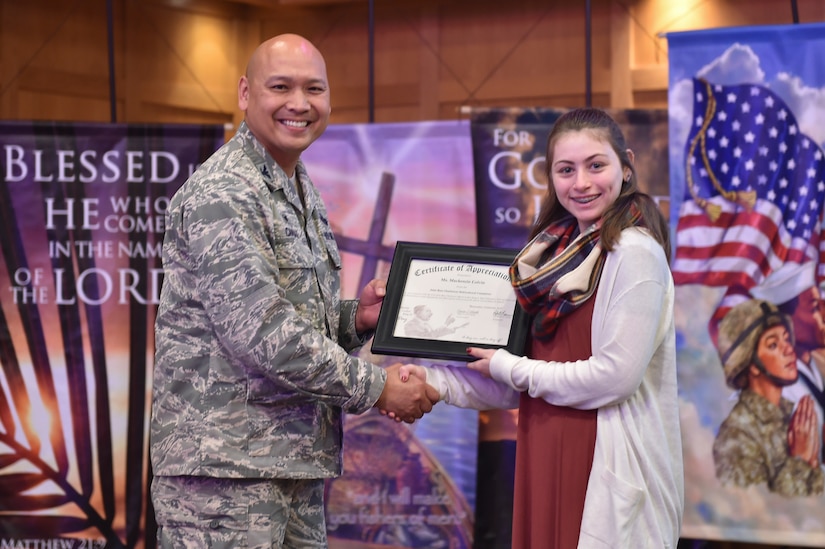 U.S. Air Force Col. Jimmy Canlas, 437 Airlift Wing commander, presents Mackenzie Colvin, a student from Gregg Middle School,  with a certificate of appreciation during the Dr. Martin Luther King Jr. remembrance event at the Air Base Chapel Jan. 17, 2017 at Joint Base Charleston, South Carolina. Colvin recited a speech written by King during the ceremony.