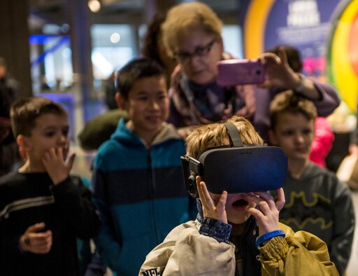 A child reacts while having a virtual reality experience at the Air Force booth.  (U.S. Air Force photo by Staff Sgt. Jodi Martinez)