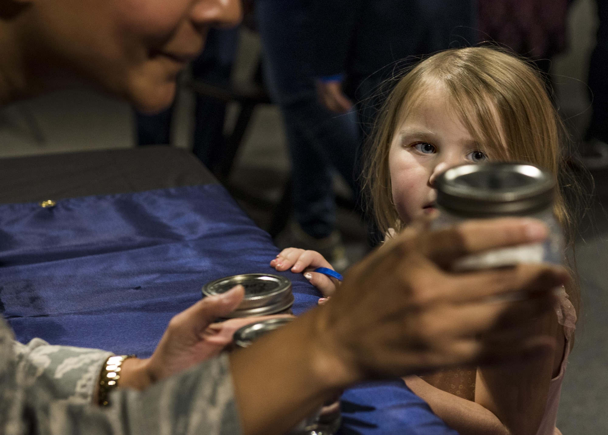 A girl looks at a jar that Maj. Anita Shade, 375th Dental Squadron residency director, holds to show the effects of acid on teeth during the event. (U.S. Air Force photo by Staff Sgt. Jodi Martinez)