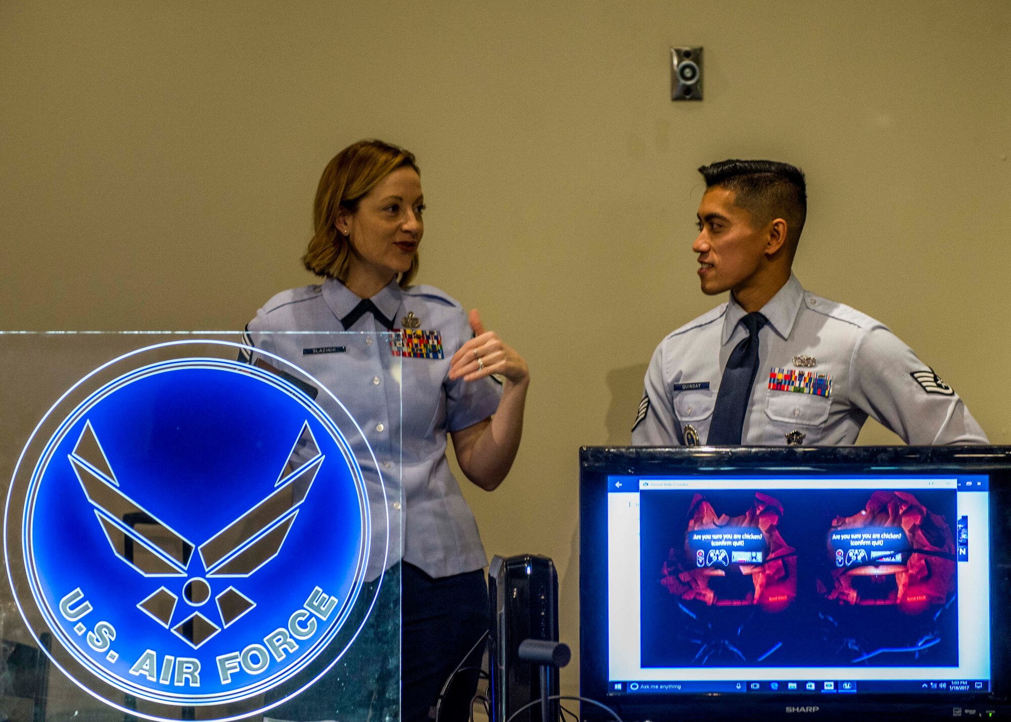 Chief Master Sgt. Diane Slazinik, 375th Communications Group superintendent, and Staff Sgt. Charles Quinsay, talk during the event next to the Air Force logo and the virtual reality screen.  (U.S. Air Force photo by Staff Sgt. Jodi Martinez)