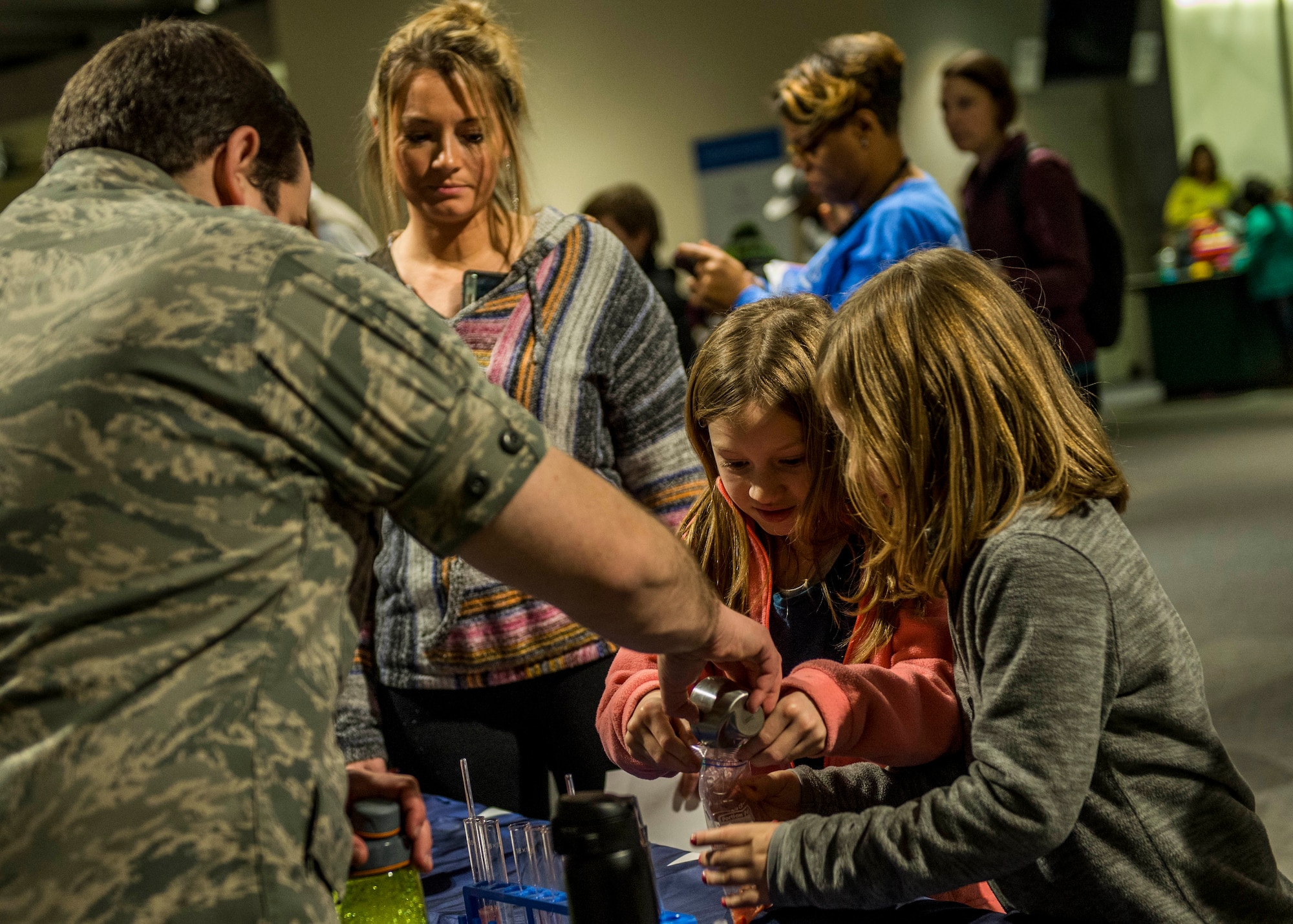 Capt. Nicholas Littman, 375th Aerospace Medicine Squadron, teaches two young girls how to extract DNA from a strawberry. (U.S. Air Force photo by Staff Sgt. Jodi Martinez) (U.S. Air Force photo by Staff Sgt. Jodi Martinez)