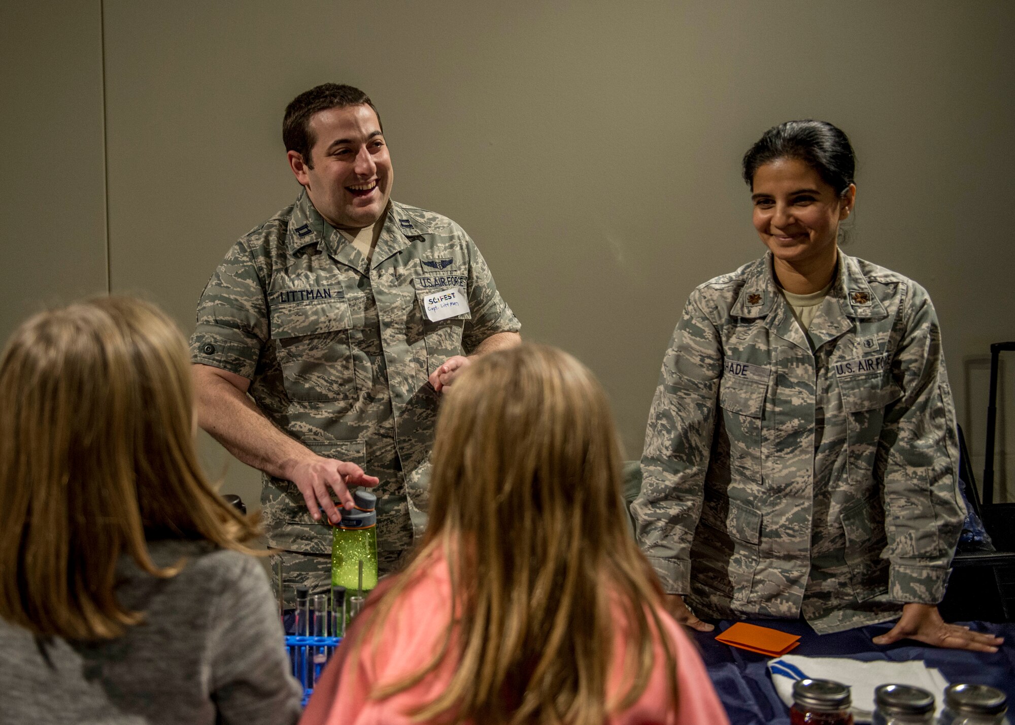 Capt. Nicholas Littman, 375th Aerospace Medicine Squadron, and Maj. Anita Shade, 375th Dental Squadron residency director, teach two young girls about the effects that acid has on teeth during the event. (U.S. Air Force photo by Staff Sgt. Jodi Martinez)