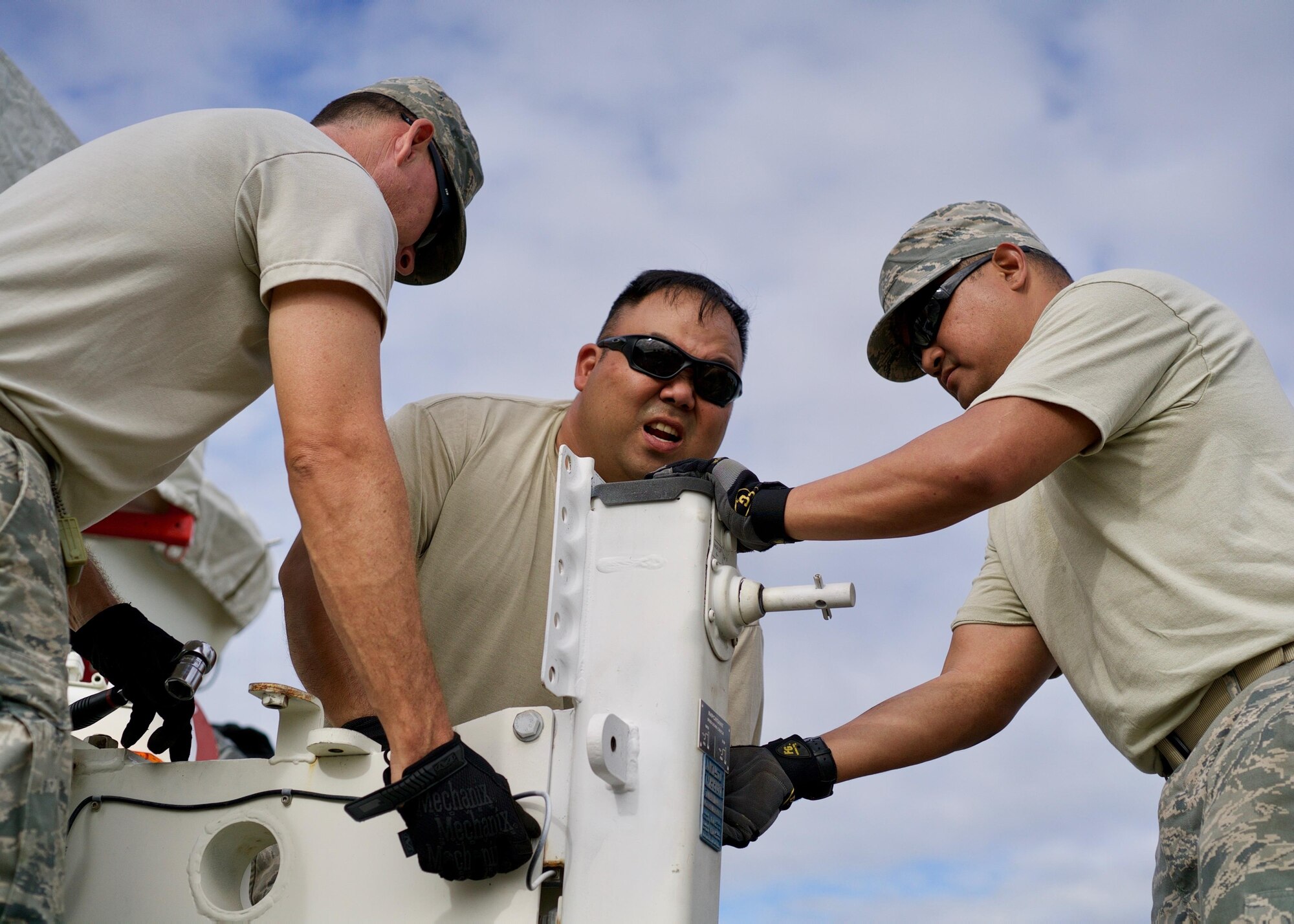 Air Force Master Sgt. Eric Martin (left), Tech. Sgt. Kyle Kikuchi (center) and Staff Sgt. Joel Fernandez (right), level a downlink antenna, Clark Air Base, Philippines, Jan. 15, 2017. Martin, Kikuchi and Fernandez are Eagle Vision team members who are deployed to the Philippines to support a Pacific Air Forces Subject Matter Expert Exchange mission. The team will work with Philippine Airmen to share how satellite imagery can help enhance Humanitarian Assistance and Disaster Relief efforts common in the Asia-Pacific.(U.S. Air Force photo by Tech. Sgt. James Stewart/Released)