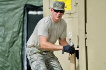 U.S. Air Force Master Sgt. Eric Martin, Eagle Vision Data Acquisition Segment non-commission officer-in-charg with the Hawaii Air National Guard, levels an expandable, two-sided, tactical shelter's support leg while setting up the Eagle Vision work site, Clark Air Base, Philippines, Jan. 15, 2017. Martin is a member of a 15-person team deployed to the Philippines to support a Pacific Air Forces Subject Matter Expert Exchange with the Philippine Air Force. The team will work with Philippine Airmen to share how satellite imagery can help enhance Humanitarian Assistance and Disaster Relief efforts common in the Asia-Pacific. (U.S. Air Force photo by Tech. Sgt. James Stewart/Released)