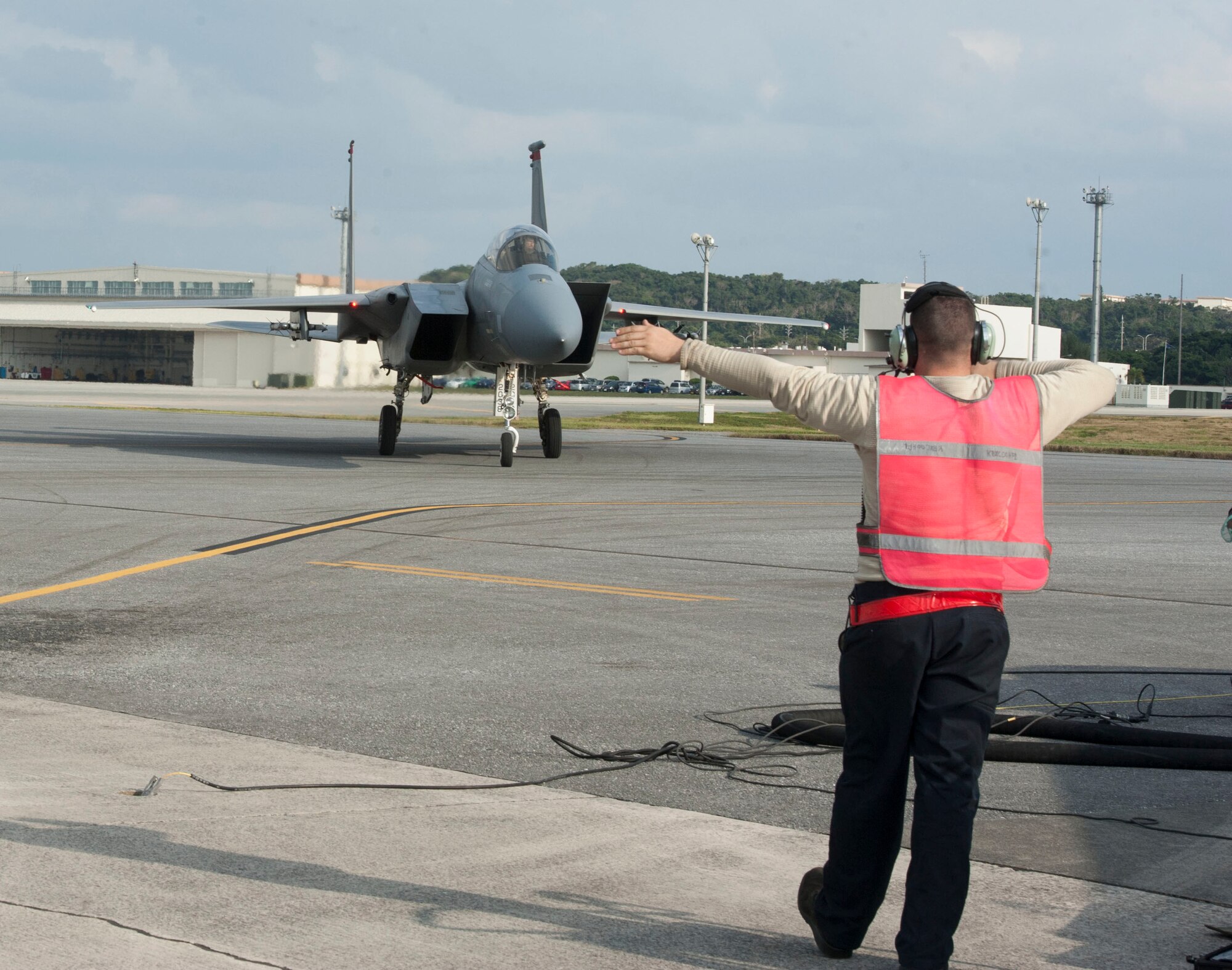 U.S. Air Force Senior Airman Justin Greaux, 18th Aircraft Maintenance Squadron crew chief, directs an F-15 Eagle during surge operations Jan. 11, 2017, at Kadena Air Base, Japan. During a surge, multiple F-15s are refueled consecutively, maintaining a high operational tempo. (U.S. Air Force photo by Senior Airman Lynette M. Rolen/Released)