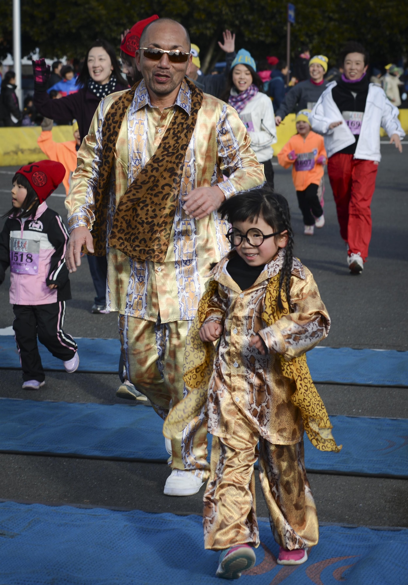 A father and daughter cross the finish line together at the 2K Family Race during the 36th Annual Yokota Striders Frostbite Race at Yokota Air Base, Japan, Jan. 15, 2017. Approximately 12,000 runners and guests attended the race this year, promoting friendship and physical fitness. (U.S. Air Force photo by Senior Airman Baker)