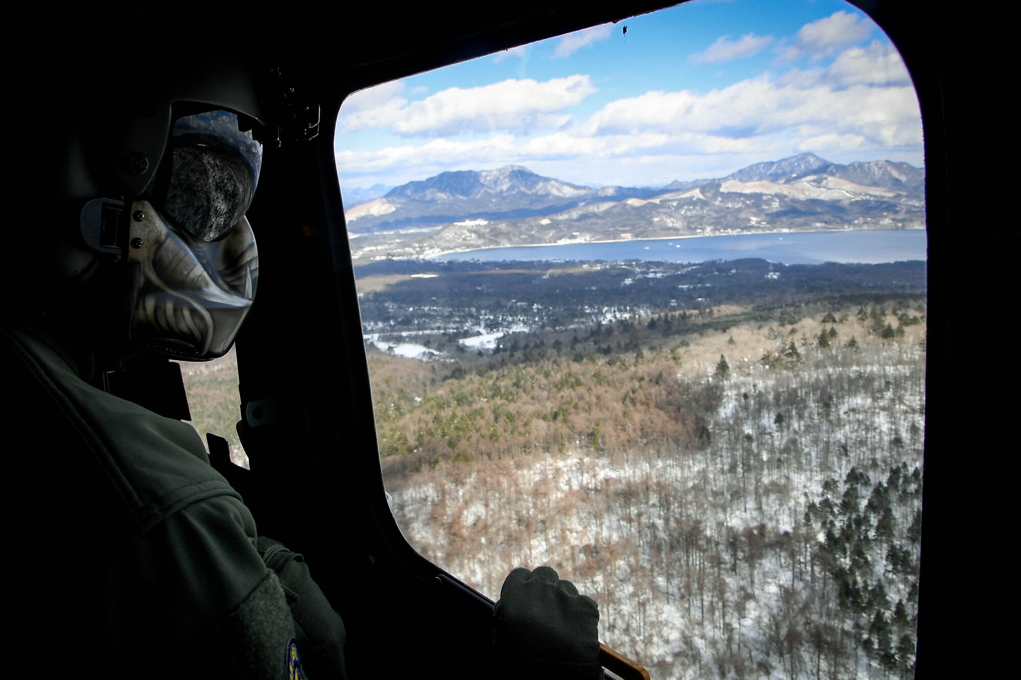 Tech. Sgt. Michael Wright, 459th Airlift Squadron special mission aviator evaluator, looks out the window of a UH-1N Iroquois to ensure the surrounding area is clear from other aircraft near Mt. Fuji, Japan, Jan. 13, 2017. The aircrew and pilots continuously check their surroundings as they follow the visual flight rules to ensure the safety of the aircrew and aircraft. (U.S. Air Force photo by Staff Sgt. David Owsianka)