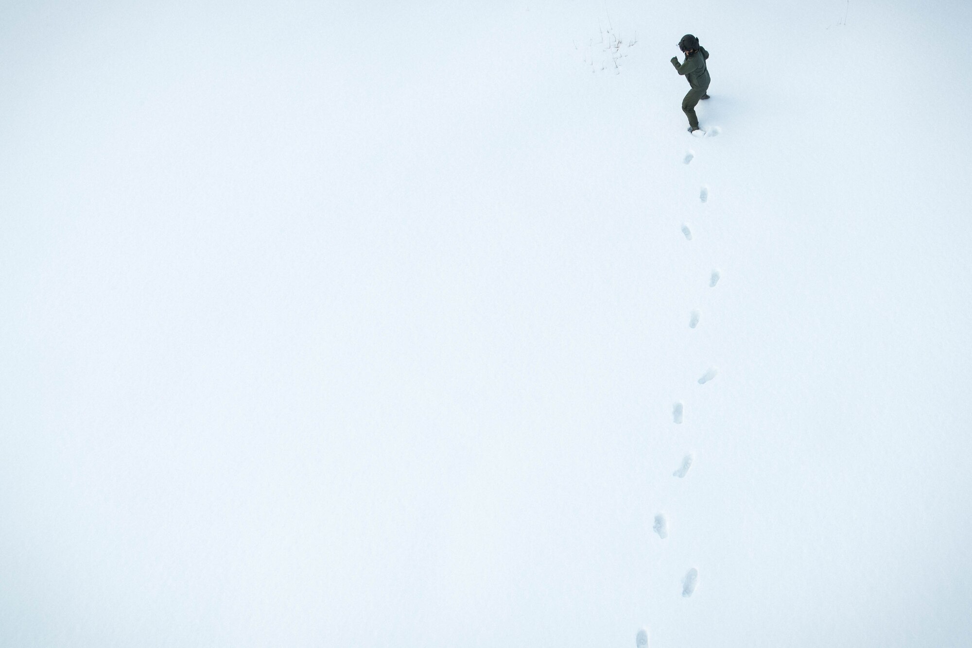 Lt. Col. Valerie Johnson, 374th Medical Group aerospace medicine chief, walks away from a UH-1N Iroquois at a drop zone near Mt. Fuji, Japan, Jan. 13, 2017. Johnson served as a ground safety observer for the hoist training to ensure the airman was safely lifted on the hoist. (U.S. Air Force photo by Staff Sgt. David Owsianka)