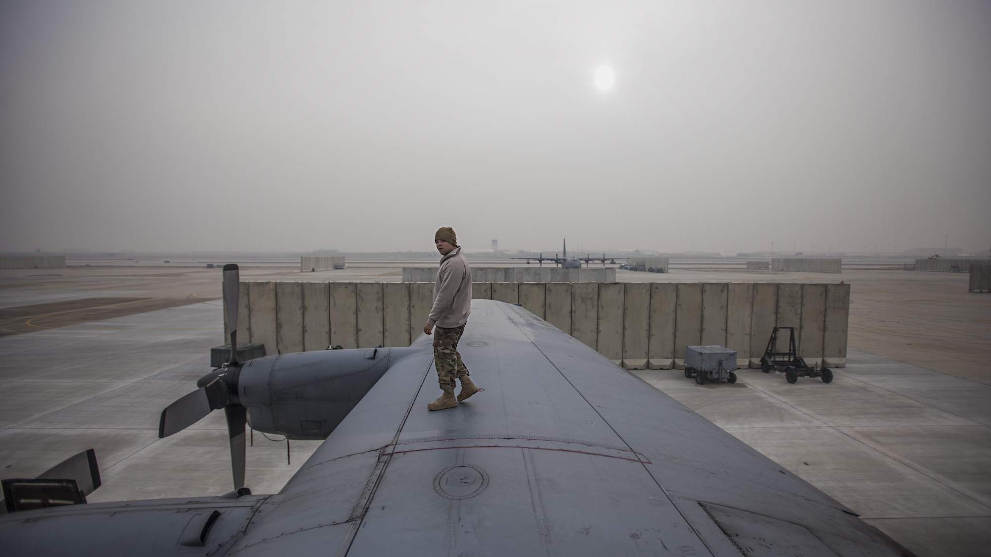 Staff Sgt. Sean Nelson, 455th Expeditionary Aircraft Maintenance Squadron crew chief, walks along the wing of an EC-130 Compass Call Jan. 18, 2017 at Bagram Airfield, Afghanistan. In the past four months, the unit has flown more than any other time of the same period in the history of the unit. (U.S. Air Force photo by Staff Sgt. Katherine Spessa)