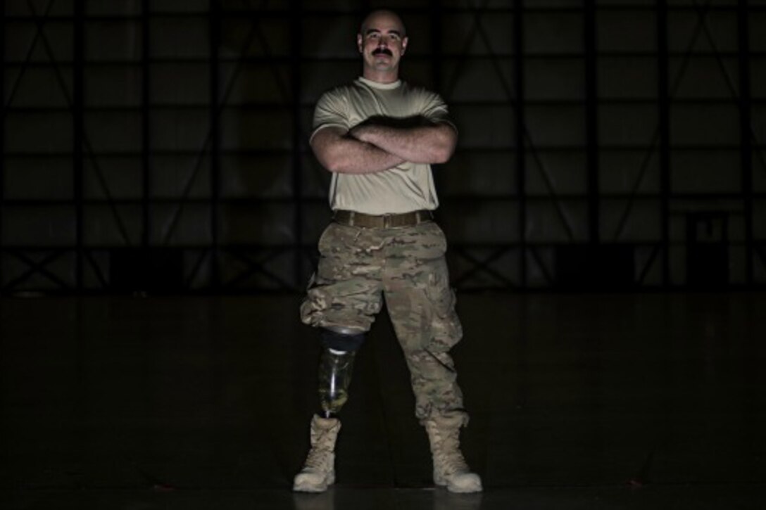 Tech. Sgt. Jason Caswell stands in a C-130 hangar at Bagram Airfield, Afghanistan, Jan. 5, 2017. After a sports injury in 2010, Caswell underwent a year of surgeries, two years of painful limb-recovery therapy, followed by physical therapy. In October 2014, his limb still hadn’t healed and began to worsen so Caswell elected to amputate his injured leg. Air Force photo by Staff Sgt. Katherine Spessa