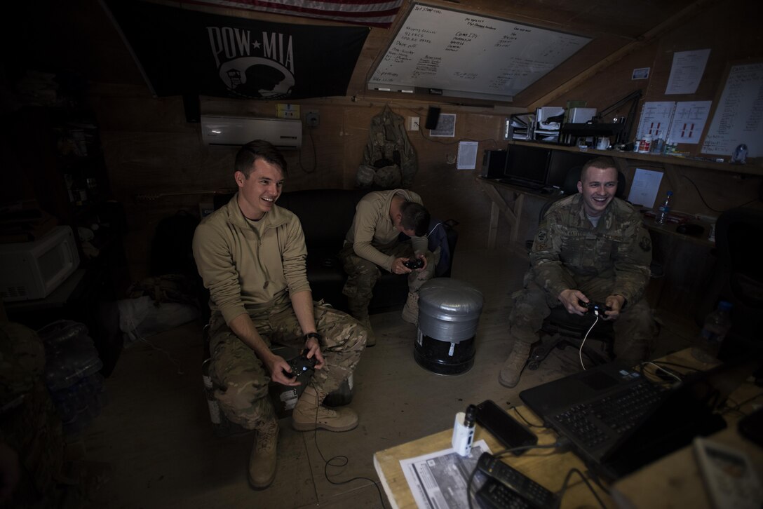 Senior Airman Domynic Panto and Tech. Sgt. Bob Kaster, 455th Expeditionary Aircraft Maintenance Squadron C-130 Compass Call Aircraft Maintenance Unit communications navigations and mission systems technicians, and Airman 1st Class Mitchell Dillon, 455th EAMXS C-130 AMU electronic warfare combat systems technician, play video games at Bagram Airfield, Afghanistan Jan. 12, 2017. When they’re not working out on the flightline, members of the AMU play sports or video games and work out together. (U.S. Air Force photo by Staff Sgt. Katherine Spessa)