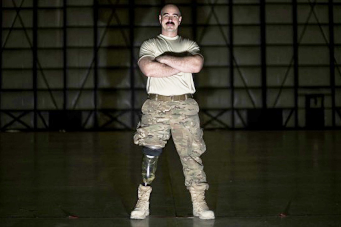 Tech. Sgt. Jason Caswell stands in a C-130 hangar at Bagram Airfield, Afghanistan, Jan. 5, 2017. After a sports injury in 2010, Caswell underwent a year of surgeries, two years of painful limb-recovery therapy, followed by physical therapy. In October 2014, his limb still hadn’t healed and began to worsen so Caswell elected to amputate his injured leg. Air Force photo by Staff Sgt. Katherine Spessa