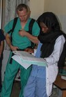 Vermont Air National Guard flight surgeon Maj. Thomas Sterling looks at Lt. Rokhaya Niasse, a Senegalese emergency medicine doctor's, notes in the emergency room during Medical Readiness Training Exercise 17-1 at Hospital Militaire De Ouakam in Dakar, Senegal, Jan. 18, 2017. MEDRETE is a combined effort between the Senegalese government, U.S. Army Africa, the U.S. Army Reserve 332nd Medical Brigade in Nashville, Tenn., and the Vermont Air National Guard. MEDRETE 17-1 is the first in a series of medical readiness training exercises that U.S. Army Africa is scheduled to facilitate within various countries in Africa, and serves as an opportunity for the partnered militaries to hone and strengthen their general surgery and trauma skills while reinforcing the partnership between the countries. The mutually beneficial exercise brings together Senegalese military and U.S. Army medical professionals to foster cooperation while conducting medical specific tasks. (U.S. Army Africa photo by Maj. Simon Flake)