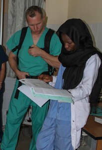 Vermont Air National Guard flight surgeon Maj. Thomas Sterling looks at Lt. Rokhaya Niasse, a Senegalese emergency medicine doctor's, notes in the emergency room during Medical Readiness Training Exercise 17-1 at Hospital Militaire De Ouakam in Dakar, Senegal, Jan. 18, 2017. MEDRETE is a combined effort between the Senegalese government, U.S. Army Africa, the U.S. Army Reserve 332nd Medical Brigade in Nashville, Tenn., and the Vermont Air National Guard. MEDRETE 17-1 is the first in a series of medical readiness training exercises that U.S. Army Africa is scheduled to facilitate within various countries in Africa, and serves as an opportunity for the partnered militaries to hone and strengthen their general surgery and trauma skills while reinforcing the partnership between the countries. The mutually beneficial exercise brings together Senegalese military and U.S. Army medical professionals to foster cooperation while conducting medical specific tasks. (U.S. Army Africa photo by Maj. Simon Flake)