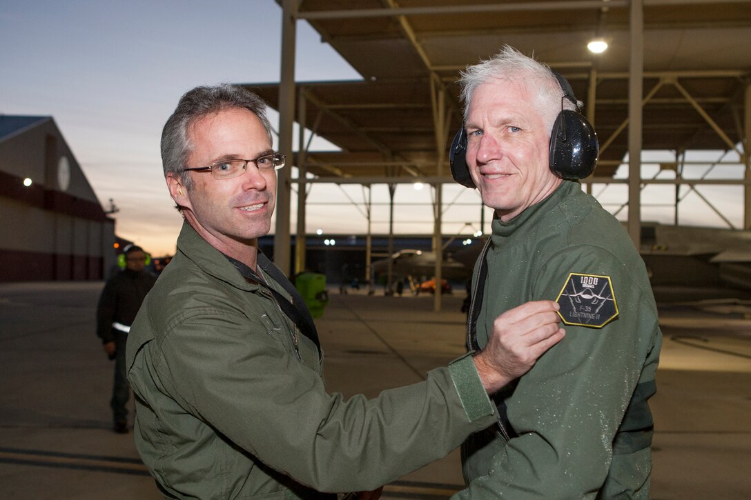 Robert Wallace (left), Lockheed Martin Flight Operations senior manager, presents David “Doc” Nelson a special flight suit patch for being the first to achieve 1,000 flight hours in the F-35 Joint Strike Fighter Jan. 6. (Courtesy photo by Tom Reynolds/Lockheed Martin)