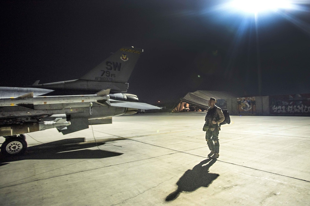 Air Force Capt. David walks out to an F-16 Fighting Falcon aircraft before a night mission at Bagram Airfield, Afghanistan, Jan. 13, 2017. David is a pilot assigned to the 79th Expeditionary Fighter Squadron. David enlisted in the Air Force in 2004 as an F-16 avionics specialist and now flies the same airframe he used to maintain. Air Force photo by Staff Sgt. Katherine Spessa