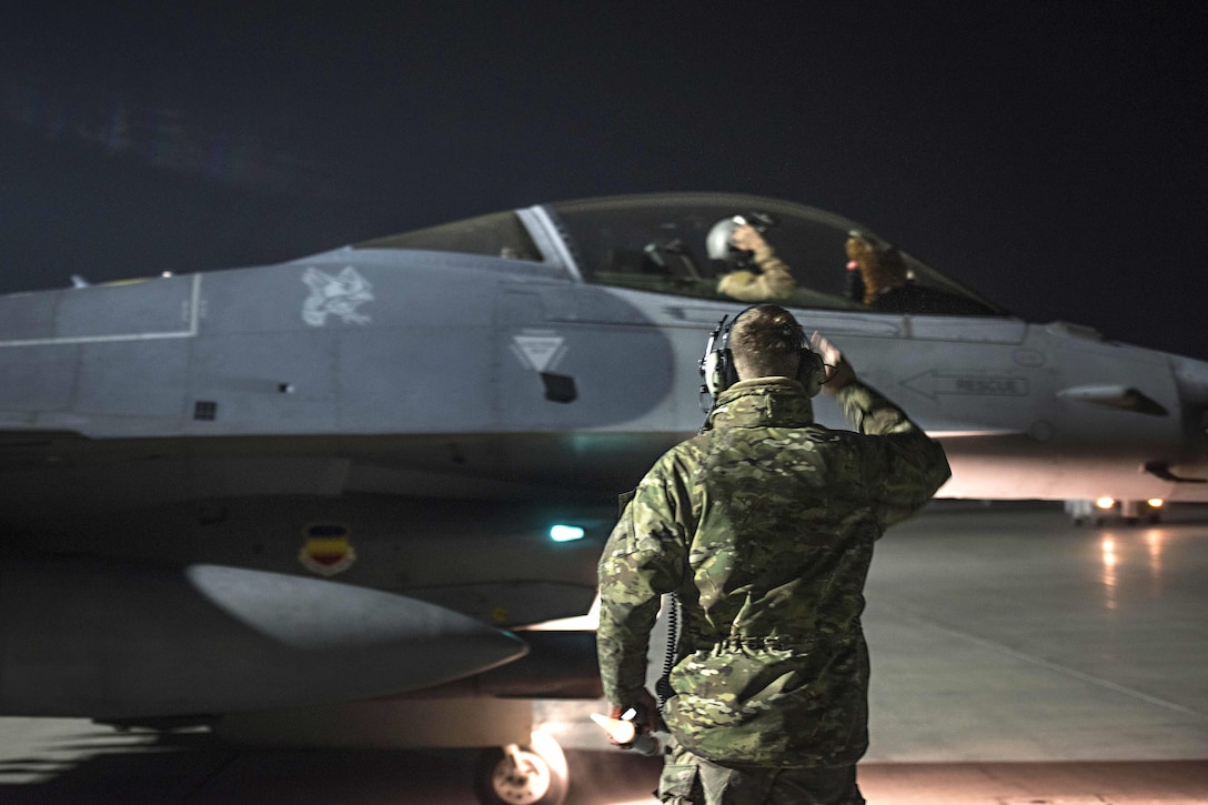 Air Force Capt. David, top, returns a salute to Air Force Staff Sgt. Daniel Lasal before a night mission at Bagram Airfield, Afghanistan, Jan. 13, 2017. David is a pilot assigned to the 79th Expeditionary Fighter Squadron. Lasal is a crew chief assigned to the 455th Expeditionary Aircraft Maintenance Squadron. Air Force photo by Staff Sgt. Katherine Spessa