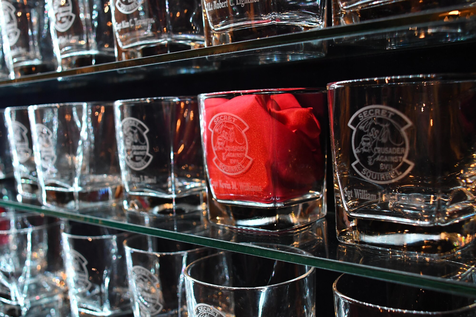 Operation Senior Surprise commemorative glasses line the wall of the Barksdale Global Power Museum at Barksdale Air Force Base, La., Jan. 17, 2017.   Every year, veterans of the mission gather to toast members of the operation still serving, those who have retired, and those who have passed away as symbolized by a red napkin in their glass.  The operation was so highly classified, members could not tell anyone about it for a year after its completion.   Because of the silence surrounding the mission, Airmen involved began referring to themselves as the “Secret Squirrels”.  (U.S. Air Force photo by Tech. Sgt. Ted Daigle/released)