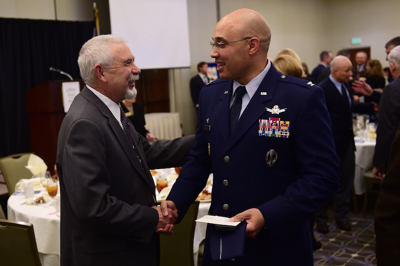 Col. David Miller Jr., 460th Space Wing commander on Buckley Air Force Base, Colo., shakes hands with George “Skip” Noe, Aurora city manager, Jan. 18, 2017, after the State of the Base in Aurora. The State of the Base allows the installation commander to review the accomplishments of 2016, and give a preview of what is to come in 2017.