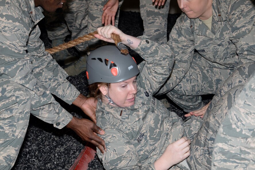 Commissioned Officer Training student receives a hand from a few teammates after losing her footing one of the obstacle courses at Officer Training School’s leadership reactionary course, Project X, Jan. 18, 2017, Maxwell Air Force Base, Ala. The goal of Project X is for its participants gain leadership and problem solving skills while brainstorming and executing a successful strategy across the obstacle. (U.S. Air Force photo/ Senior Airman Alexa Culbert)